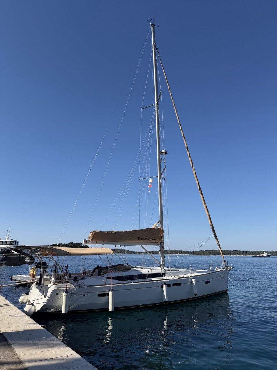 Everything Zen side profile at the dock with mast and boom cover visible